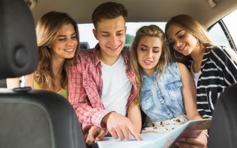 amigos-sentados-no-banco-carro-de-tras-apontando-para-o-mapa